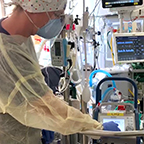 A member of the ECMO team at Banner – University Medical Center Phoenix adjusts settings on the ECMO circuit in a patient room in the Intensive Care Unit.