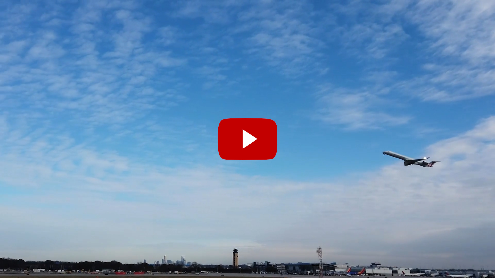 YouTube video image of airplane in clear blue sky with red video play button
