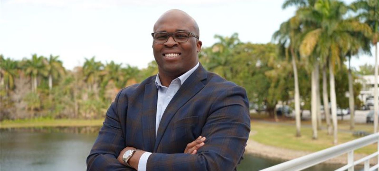 Arie Kouandijo with arms crossed in front of lake