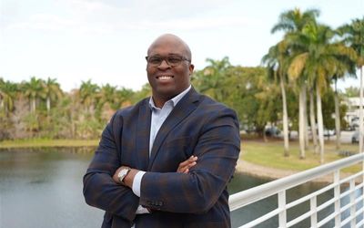 Arie Kouandijo with arms crossed in front of lake