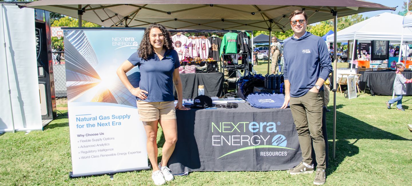 Woman and man in front of NextEra Energy Resources tent 