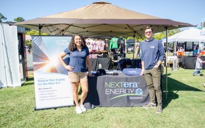 Woman and man in front of NextEra Energy Resources tent 